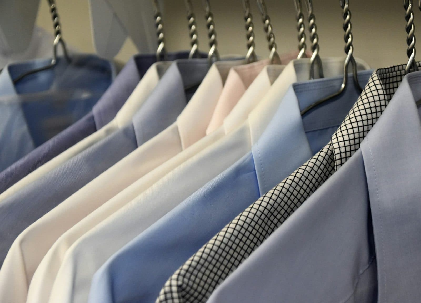 Freshly pressed shirts hanging on a dry cleaning rail